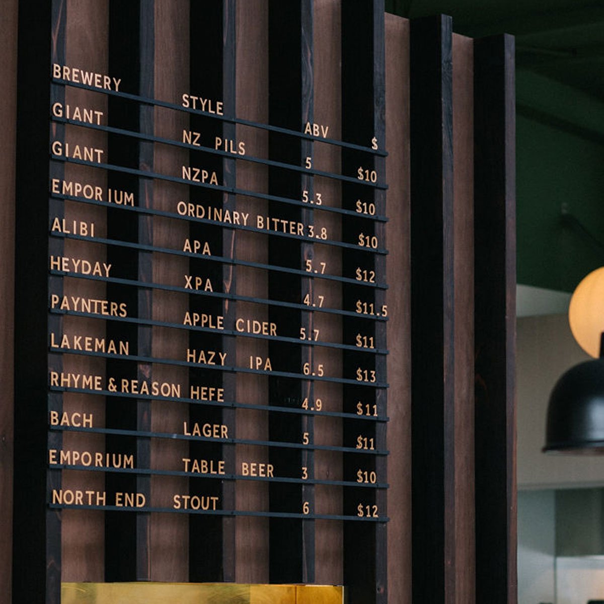 Close-up of aluminum letter menu in black rail finish with brass-colored letters