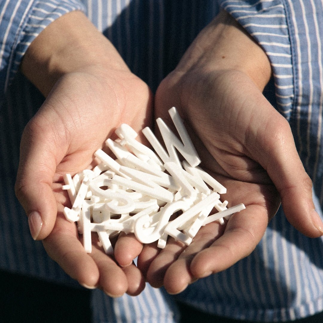 hand holding white peg letters