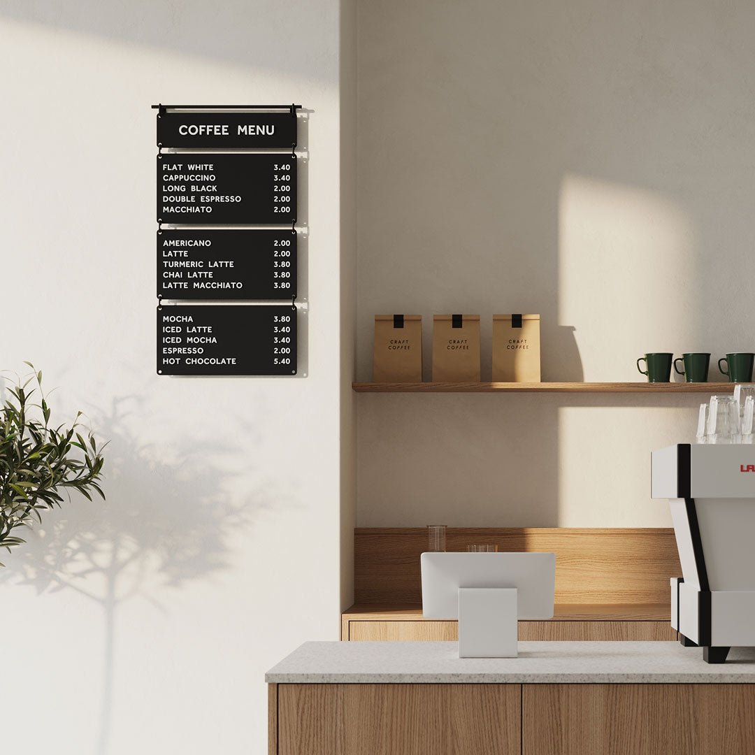 black hanging cafe menu installed on a wall beside a coffee countertop