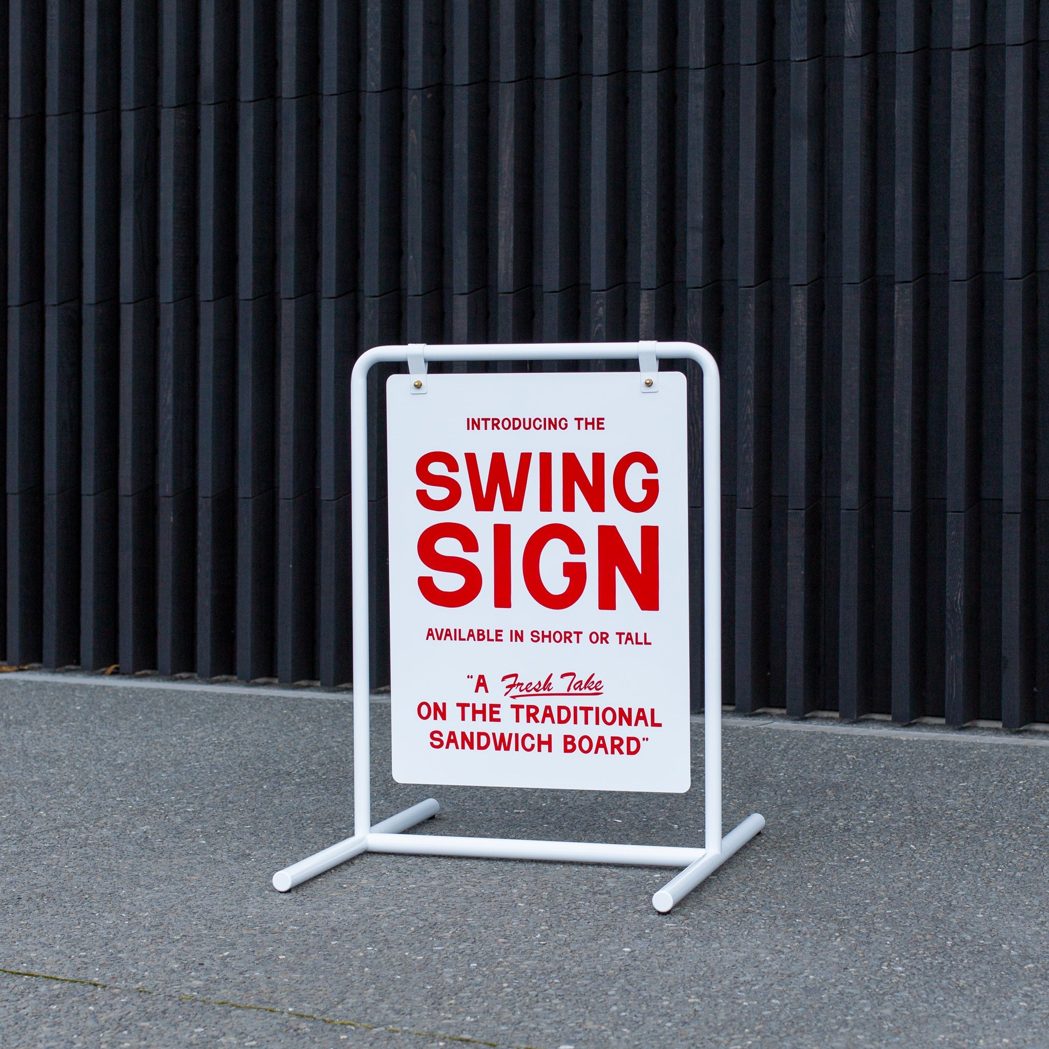 white swinging style metal signage in front of a shed with red logo branding