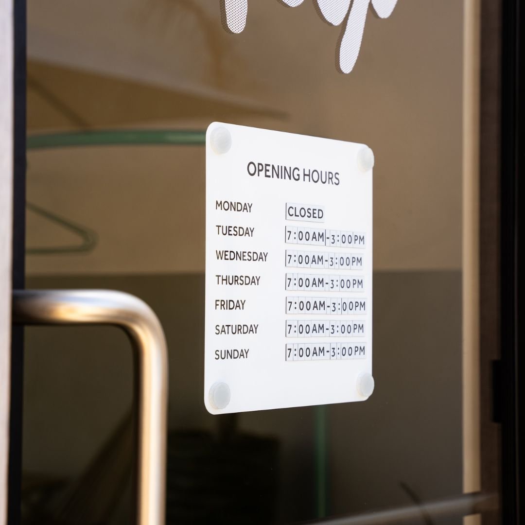 Opening Hours Sign for window mounted on shopfront glass door with handle