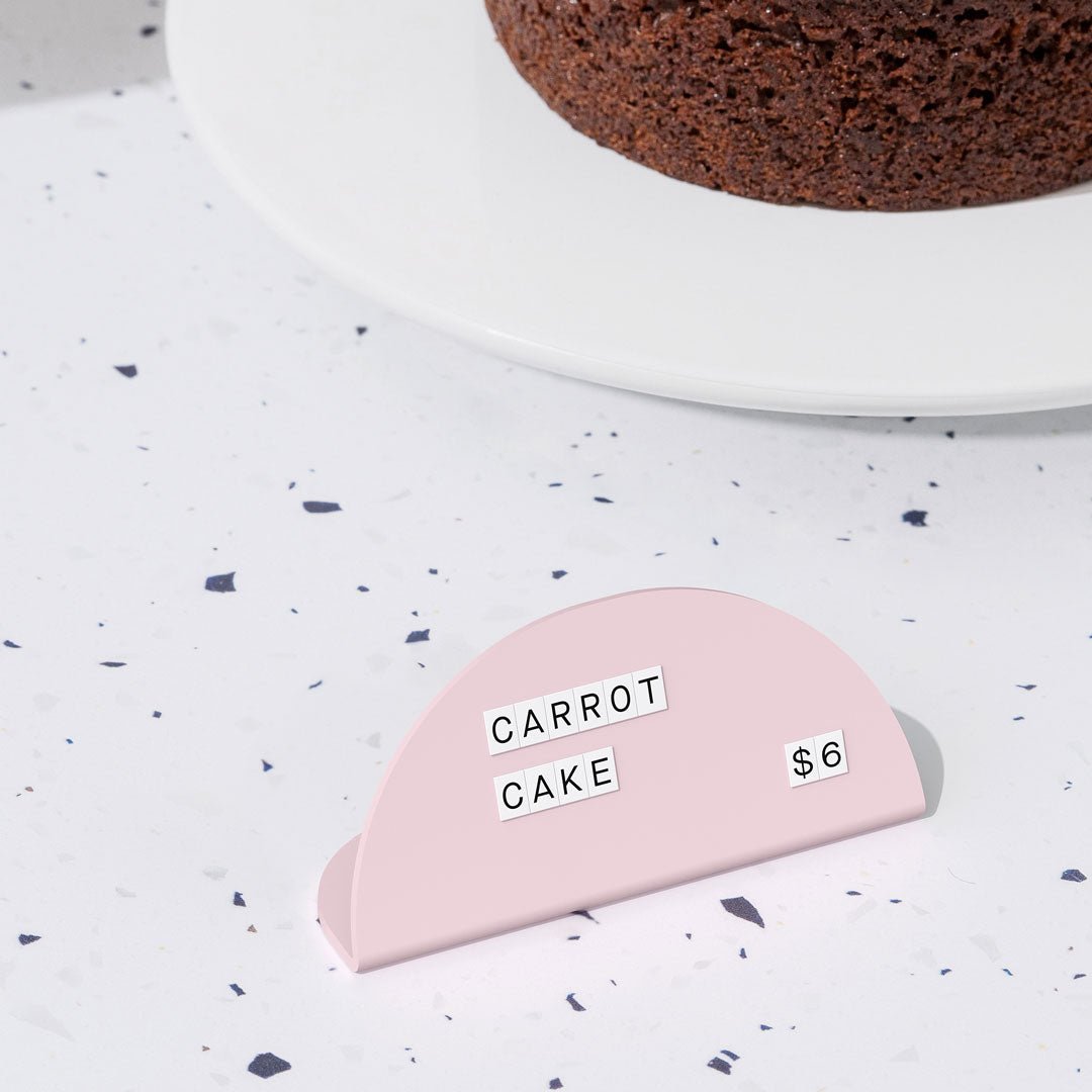 pink round counter signs with white tiled letters on a countertop