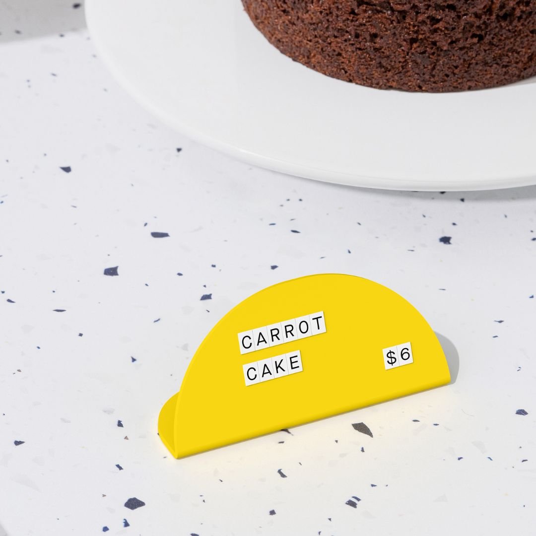 yellow round counter signs with white tiled letters on a countertop