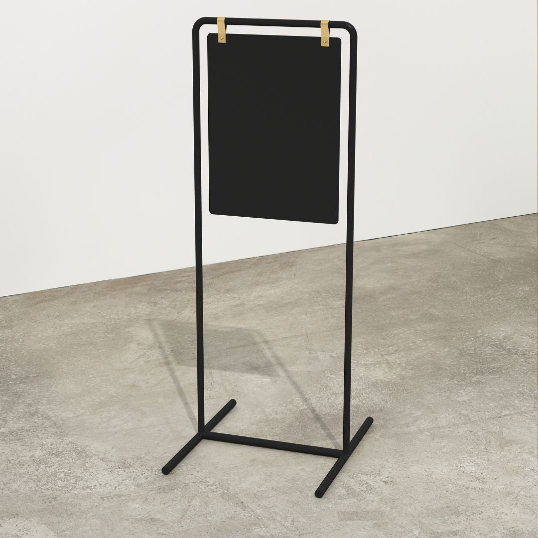 plain black metal swing sign in tall orientation inside a studio
