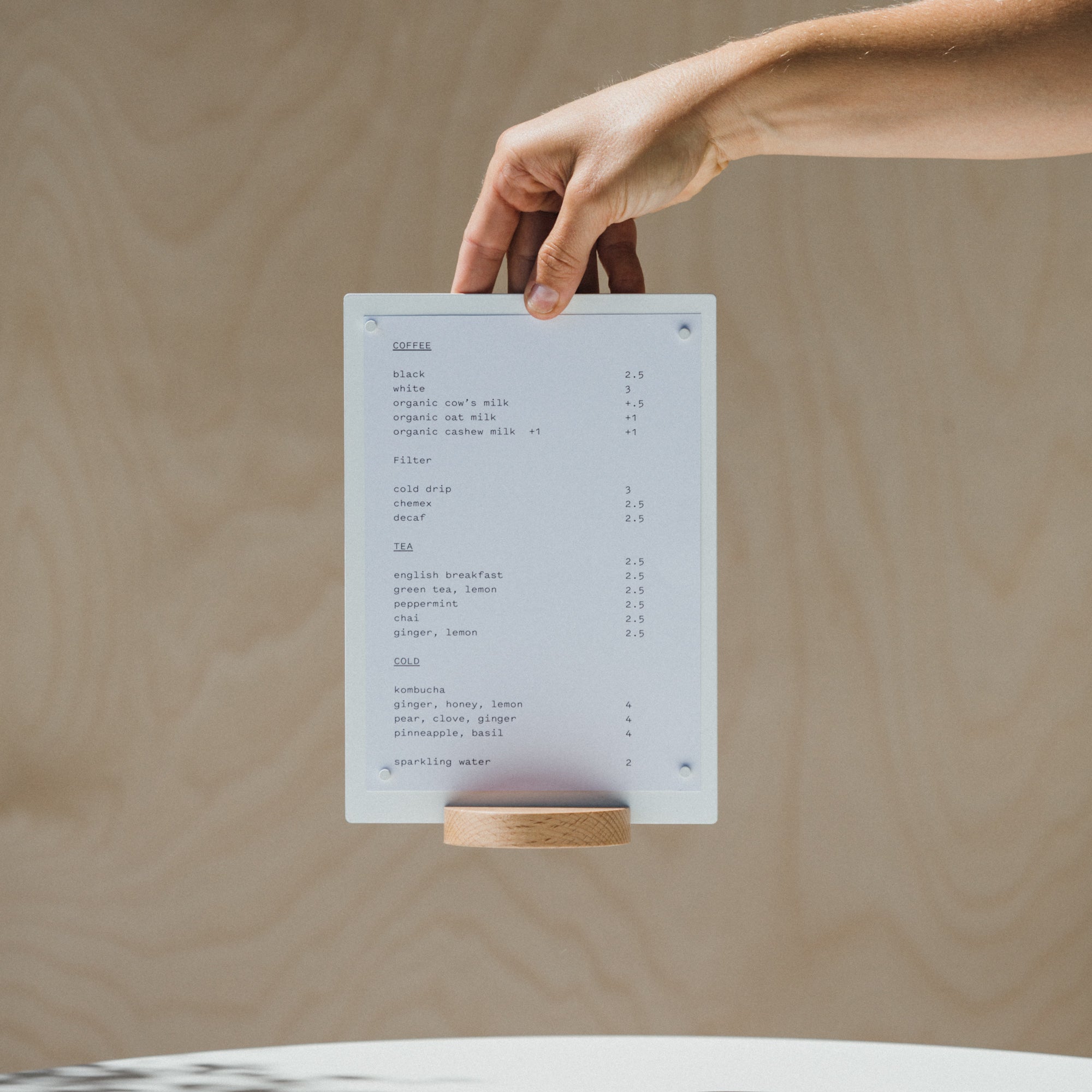 hand holding up a white table talker displaying a paper menu