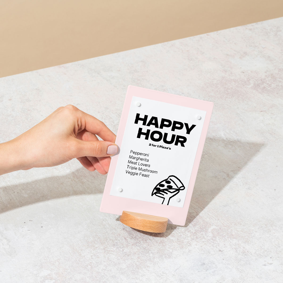 hand holding table talker in pink showing happy hour message