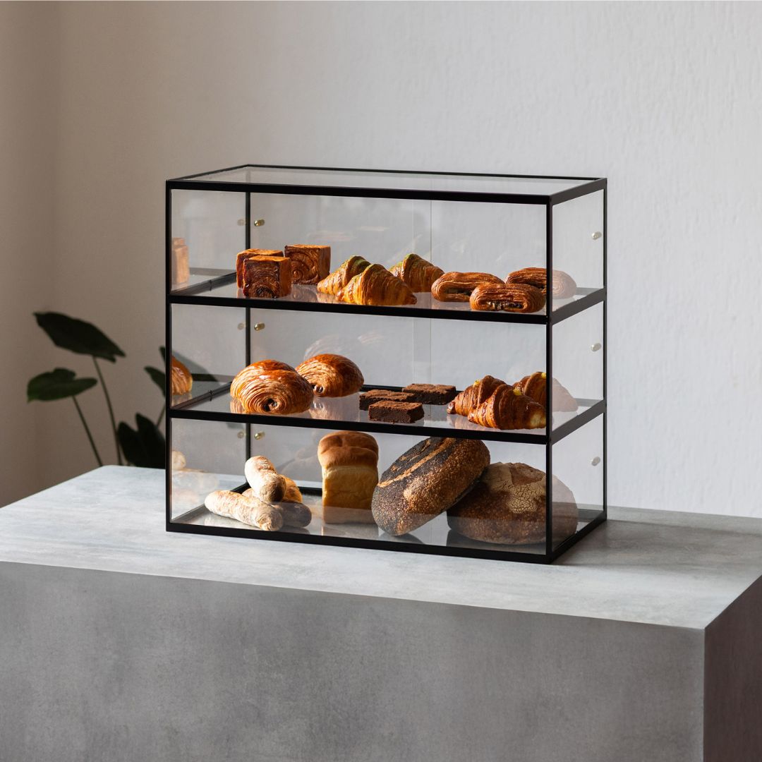 three-tier bakery display case on top of counter in studio with pastries displayed