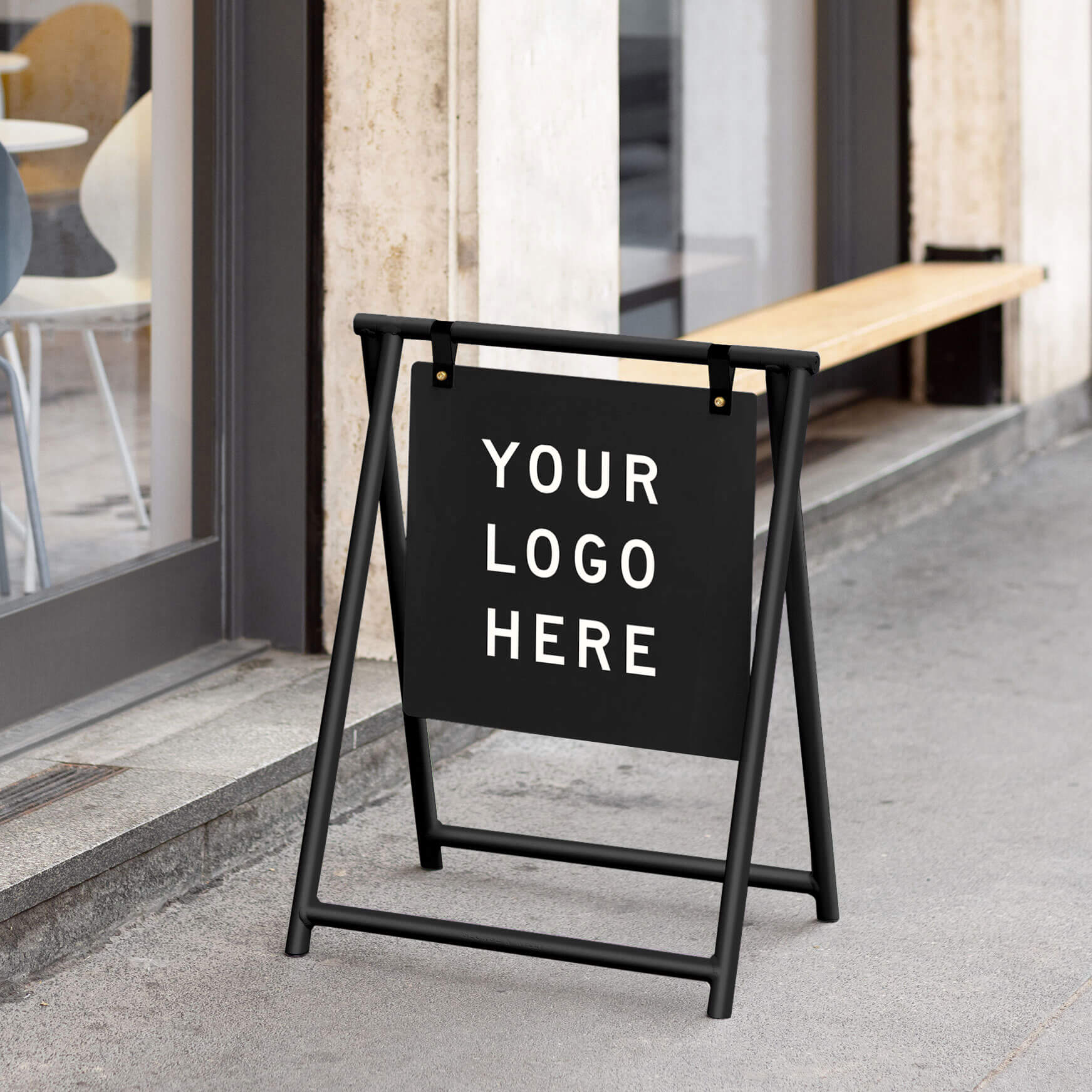 A Frame sandwich board sign in black metal finish placed outside café entrance showcasing example text
