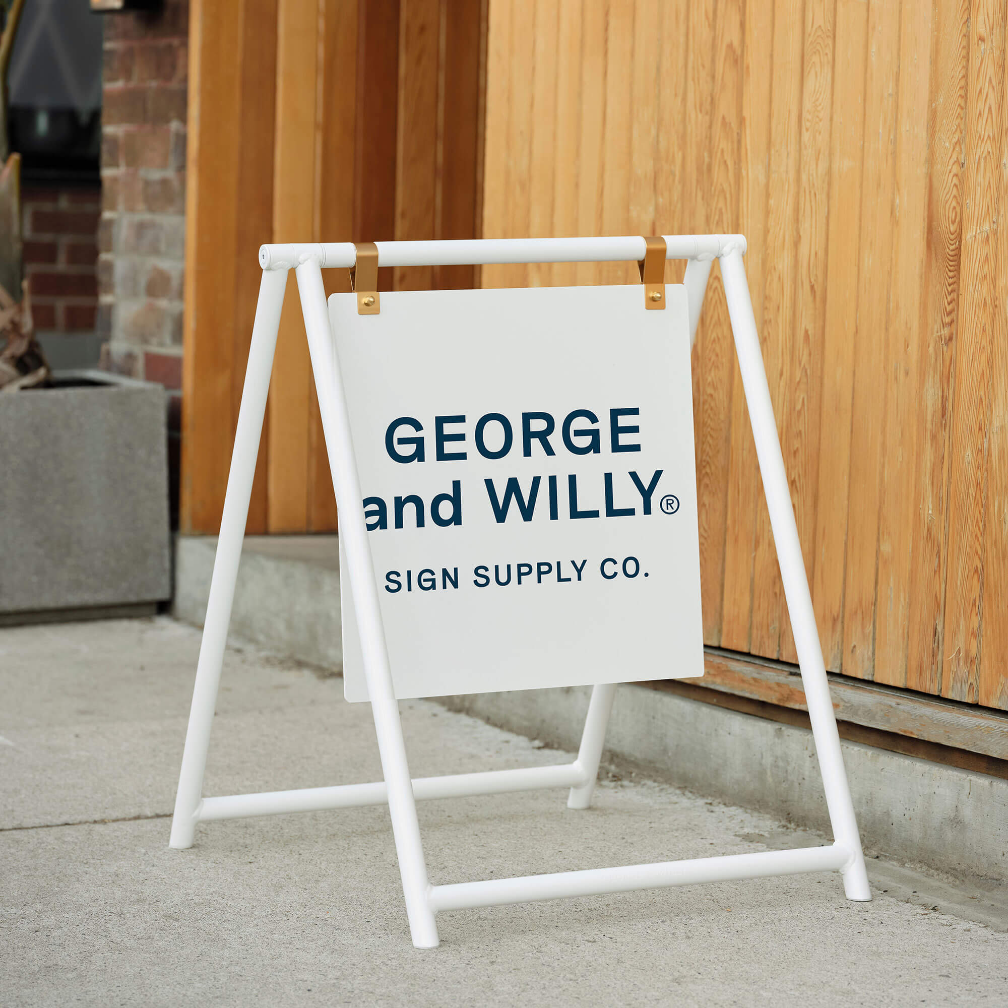 White A Frame sidewalk sign with printed café branding, positioned on sidewalk by store