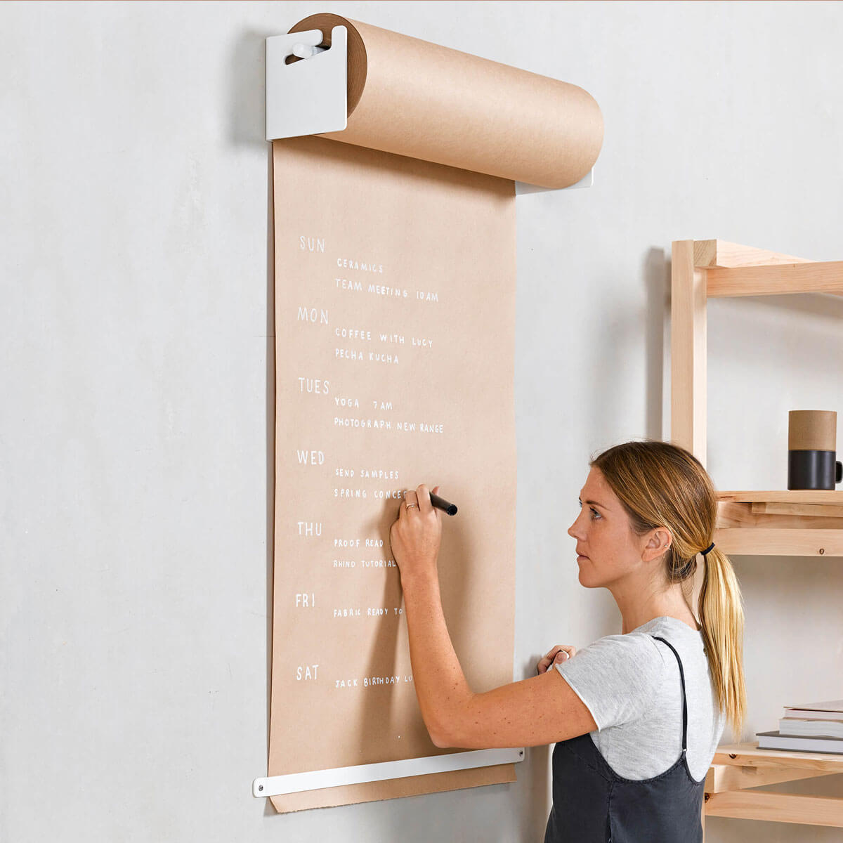 girl writing on a white studio roller