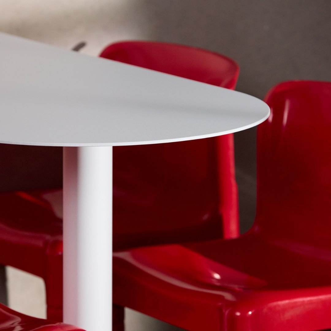 Close-up of white aluminum booth table top showing curve of table
