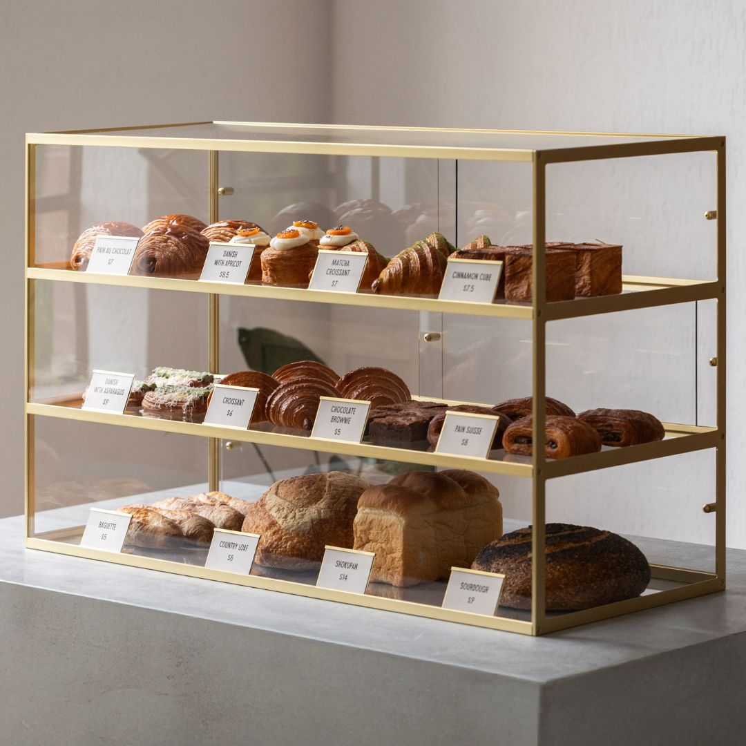 brass coloured three-tier bakery display case with pastries displayed 