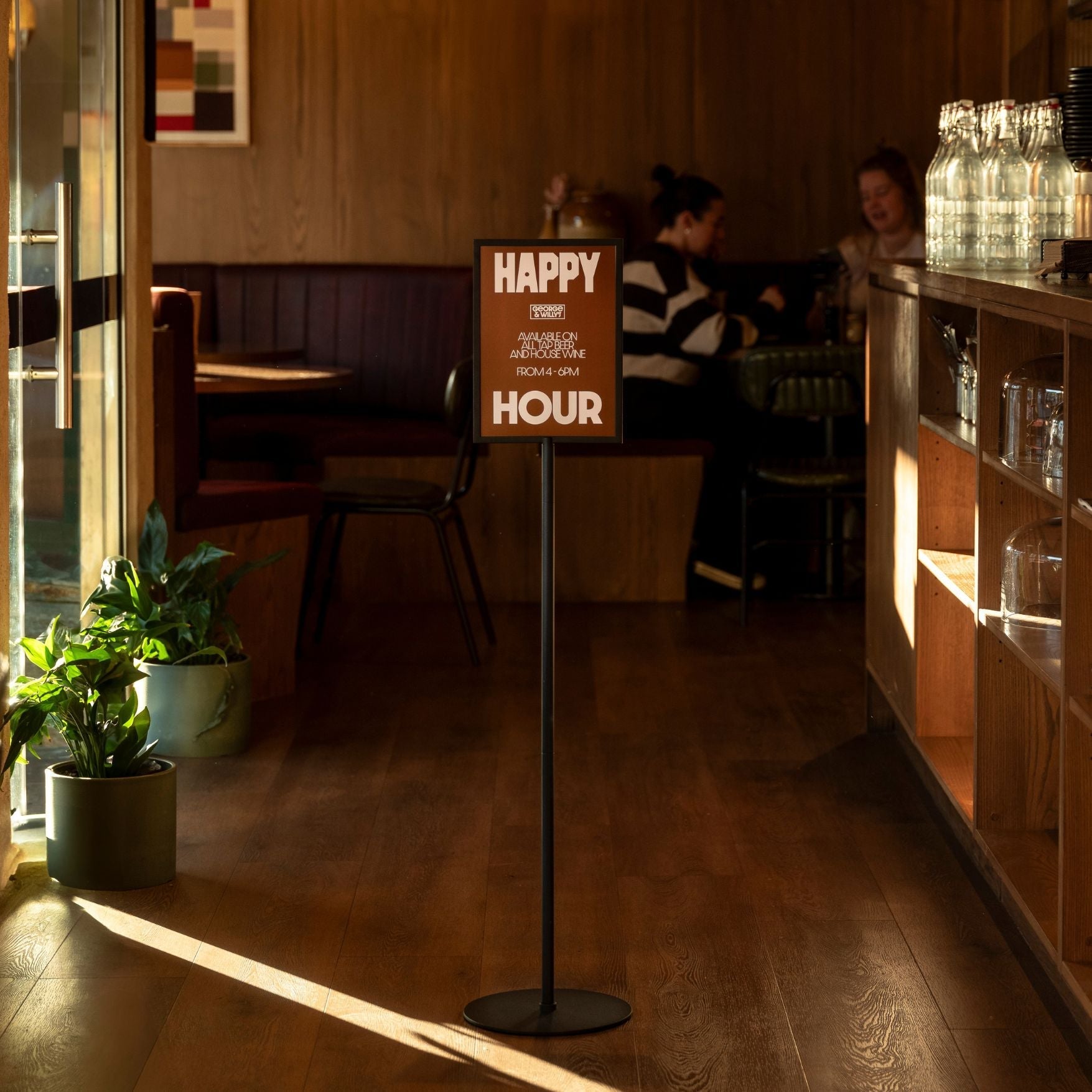 black framed standing sign holder inside a  restaurant with a sign displayed