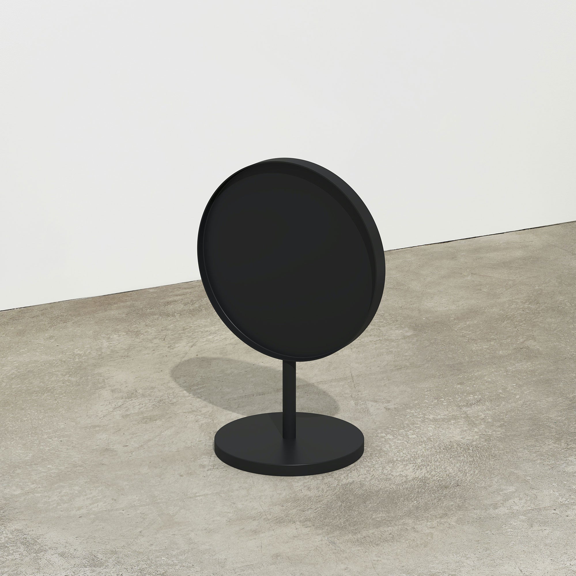 plain black circle sidewalk sign inside studio