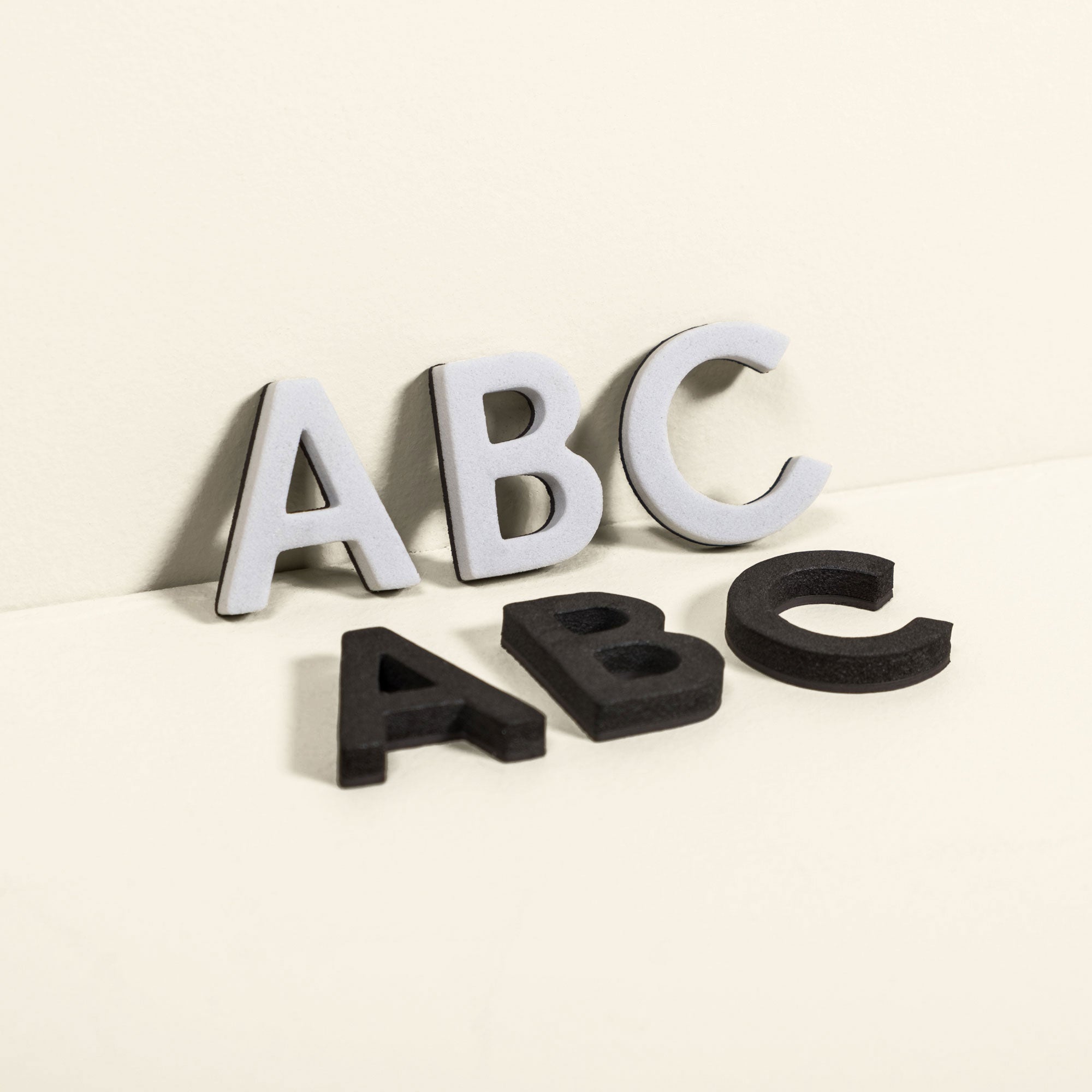 white and black "A B C" magnet letters to show magnet letters are included